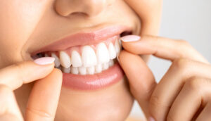Close-up of a woman proudly showcasing her bright, healthy white teeth and perfect smile. Ideal for dental care, oral hygiene, and cosmetic dentistry visuals.