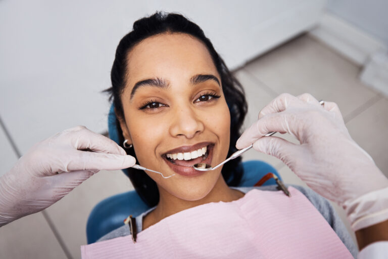 Dentist, portrait and woman in clinic with exam, checkup tools or cavity assessment in oral care. Smile, patient or orthodontist with mouth mirror, tooth health or consultation in dental appointment