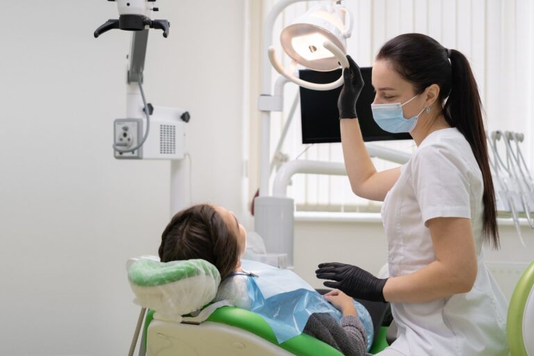 Dentist in office with dental equipment treating a patient's teeth, representing same-day CEREC crown care at The Smile Architects