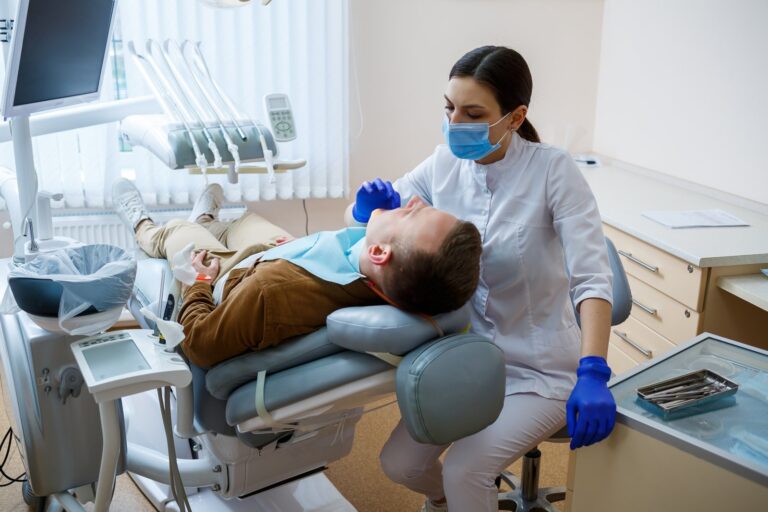 Dentist reviewing a patient's teeth during a first visit exam at The Smile Architects